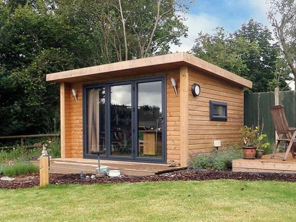 A cedar-clad garden room with sliding doors, finished in Fife